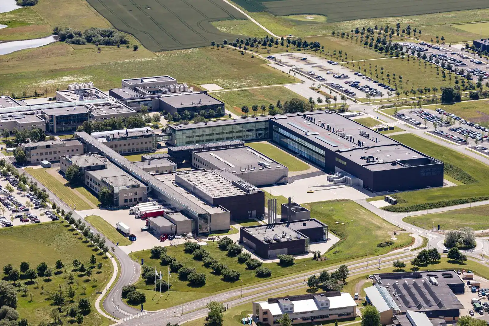 Aerial view of El-Team Sjælland ApS industrial facility with multiple buildings and green surroundin.