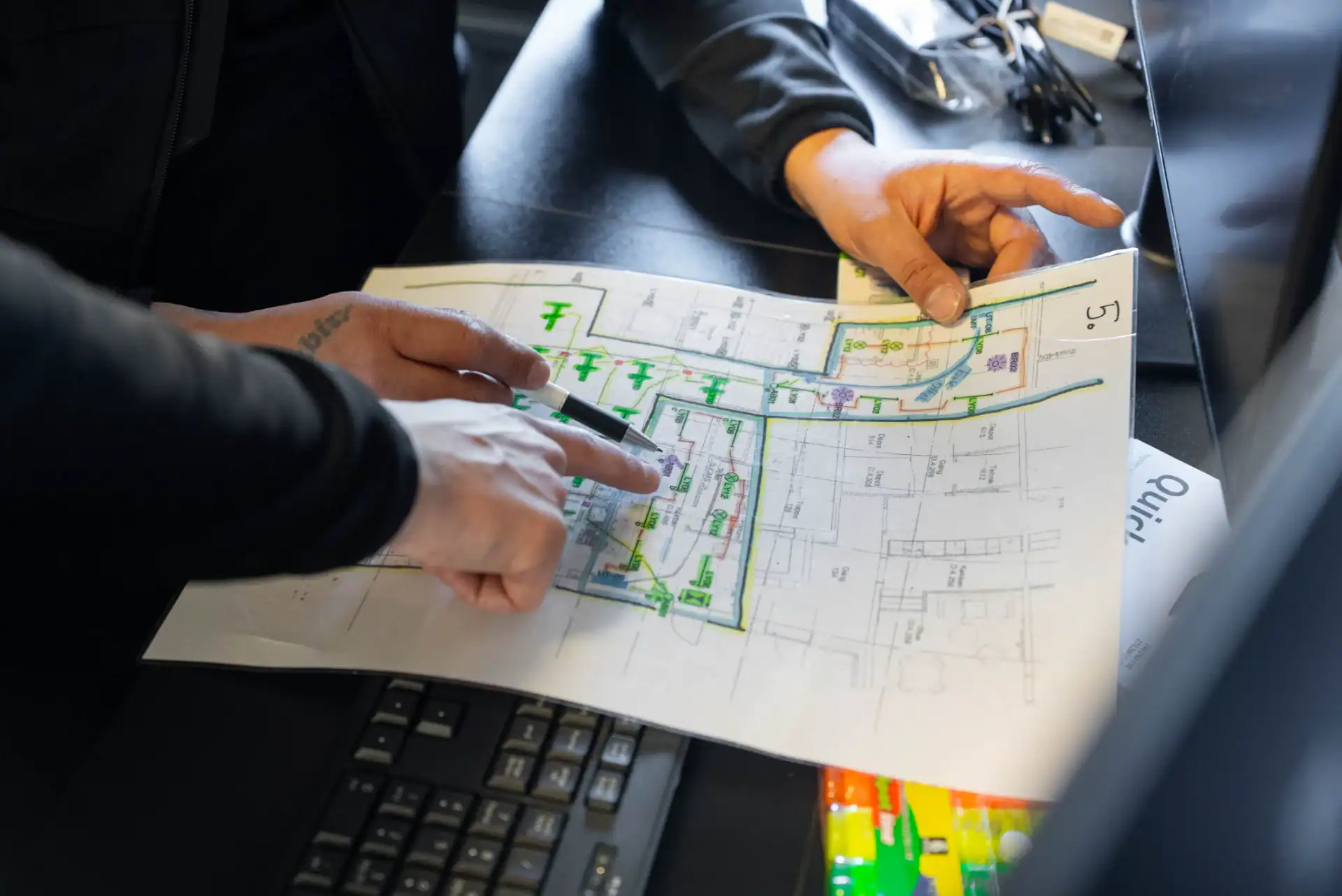 Personer gennemgår byggetegning med fokus på infrastrukturplaner.