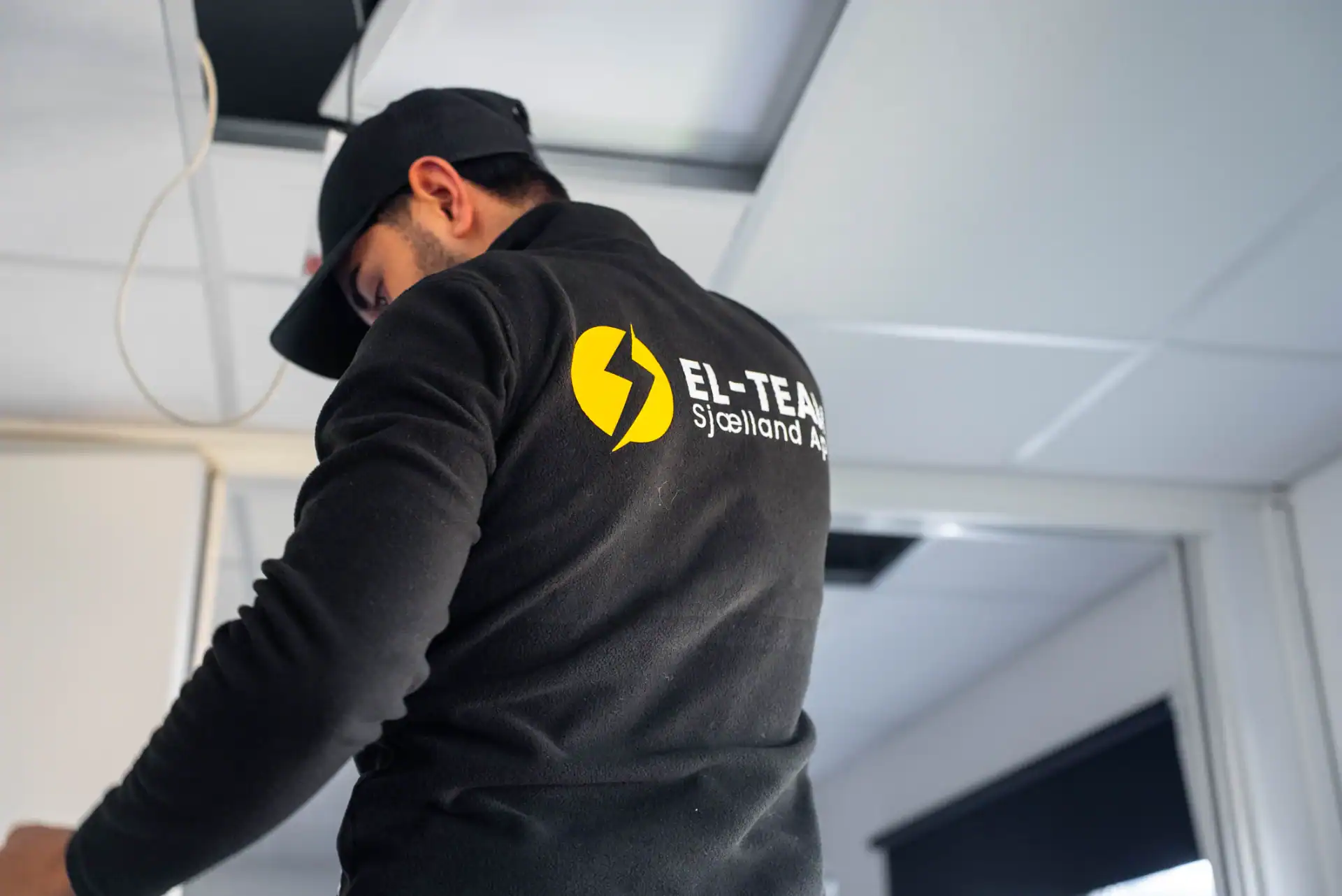 EL-TEAMSJÆLLAND logo på arbejdstager i uniform.